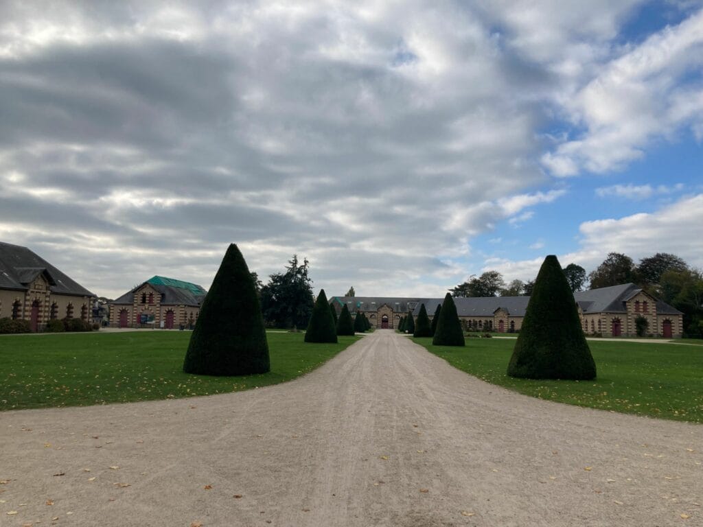 une allée d'arbuste et une bâtiment au fond